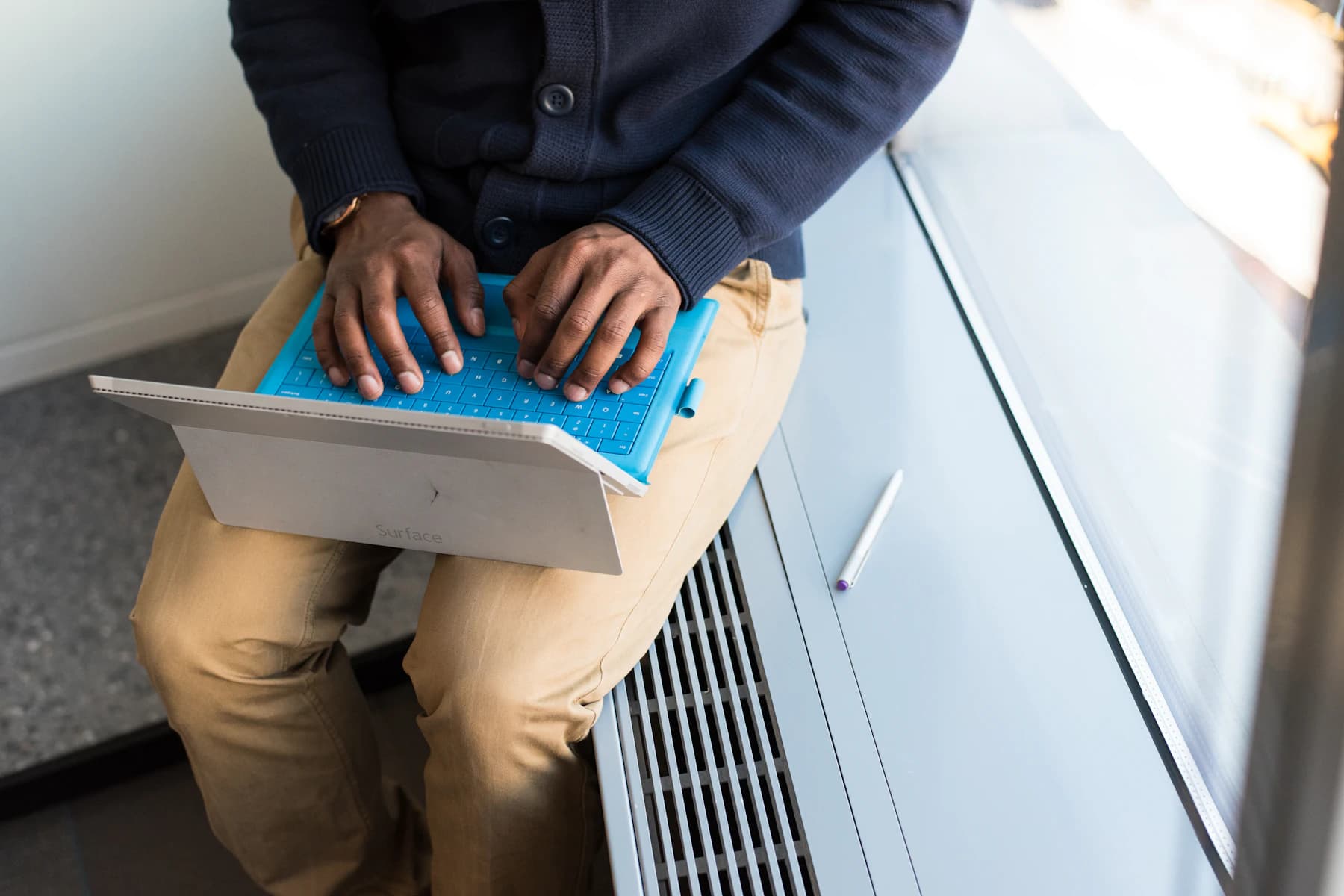 Black technician working on a laptop and mobile device