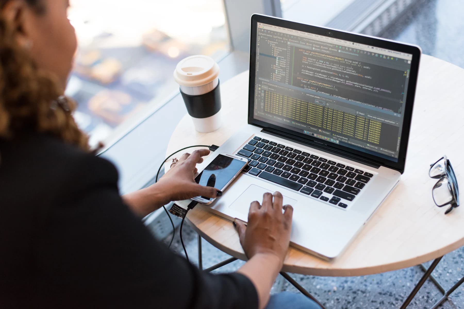 Black woman developer working on code from a laptop